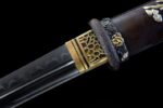 Premium Tanto guard close-up, showcasing engraved golden dragon motif and fuchi.