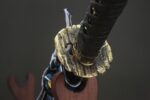 Dawnbringer tsuba close-up, showcasing metallic texture and handle joint details