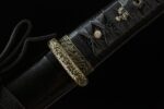 Night Blade sword, close-up of black scabbard and ornate hilt connection, showcasing golden embellishments and fine craftsmanship.