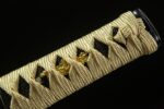 Battle of Shadows Wakizashi handle close-up, showcasing golden menuki and intricate wrapping