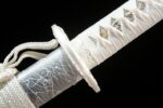 Little White Dragon Wakizashi, close-up of the scabbard and hilt merging point, showcasing the intricate connection of the white ito wrap and engraved silver fittings, highlighting the katana's assembly craftsmanship.