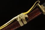 Emperor's Golden Blade scabbard red mottled texture, featuring golden sageo cord wrapping and knot, for securing and decoration
