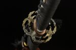Toyama Dragon Sword exquisite openwork tsuba and black wrapped handle close-up, showcasing intricate design and artistic beauty