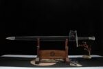 Knight Sword, full view on wooden display stand, black scabbard, elegant presentation.