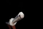White Lotus Knife handle end close-up, showing its finishing design and white wrapping details.