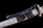 White Lotus Knife, detail of the black lacquer scabbard's mid-section, showcasing its smooth, even surface and subtle reflections, emphasizing the saya's fine polish.