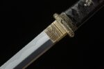 Night Blade sword, close-up of black wrapped hilt and silver blade connection, showcasing ornate gold carvings and fine craftsmanship.