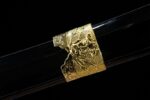 Half-Tachi scabbard section, gold embossed pattern on black base, enhancing visual and tactile appeal.