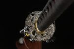 Salo knife handguard, intricate carving, gold and silver color scheme, provides hand protection and aesthetics