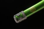 Shogun Tachi scabbard end close-up, showcasing its dark green lacquer finish and metallic end fitting, harmonious in structure and color.