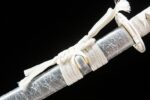 Little White Dragon Wakizashi scabbard partial view of white wrapping cord, securing the handle, showcasing delicate craftsmanship.