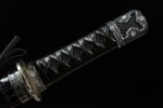 Mo Yulong Knife hilt full view, tightly woven black cotton cord forming a diamond pattern, complemented by silver fuchi and kashira featuring intricate dragon carvings, showcasing the handle's complete form and design.