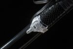 Space Warrior scabbard texture close-up, showing mesh or carbon fiber pattern.