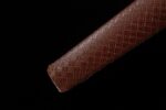 Wind Messenger sword, close-up of brown woven texture scabbard end, showcasing intricate pattern and durable material.