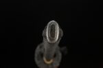 Buddha and Demon Sword handle end cap. Dark metallic kashira with unique embossed texture or character design, a refined hilt finishing ornament.