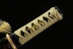 Battle of Shadows Wakizashi handle menuki close-up, showcasing golden details and wrapping texture