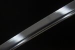 Salo knife blade partial view, glossy surface with clear hamon, showcasing exquisite forging craftsmanship