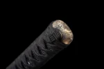 Tang Bohu Dian Qiuxiang handle pommel (kashira) close-up with black tsuka-ito wrap and brass chrysanthemum engraving, training samurai sword, wooden samurai sword