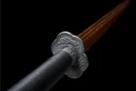 Wooden Embroidered Spring Knife tsuba guard close-up with floral relief carving in black alloy, training samurai sword, wooden samurai sword