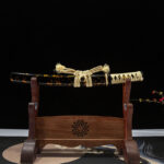 Battle of Shadows Wakizashi full view. Short sword on wooden stand. Black scabbard with gold flakes, beige handle wrap and sageo. Exquisite craftsmanship.
