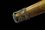 Decorative brass end cap on gold lacquered saya