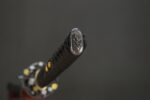 Close-up of Dark Plum katana hilt showing brass fittings