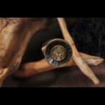 Chibi Xiaohan Sword, close-up of the pommel, showing detailed brass carving and metal texture.