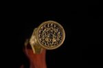 Dragon God Sword hilt end close-up, showing intricate brass fittings, carved texture, and classic design details.