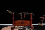 Mongolian knife displayed on a wooden stand, showing its complete form and accessories
