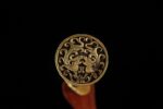 Imperial Sword pommel, circular form with delicate engravings, close-up.
