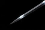 Lightweight European sword, a detail shot of the unsheathed tip, highlighting its sharp cutting edge and bright luster.