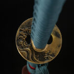 Red Night Sword round tsuba and blue handle close-up, golden carving and wrapping details